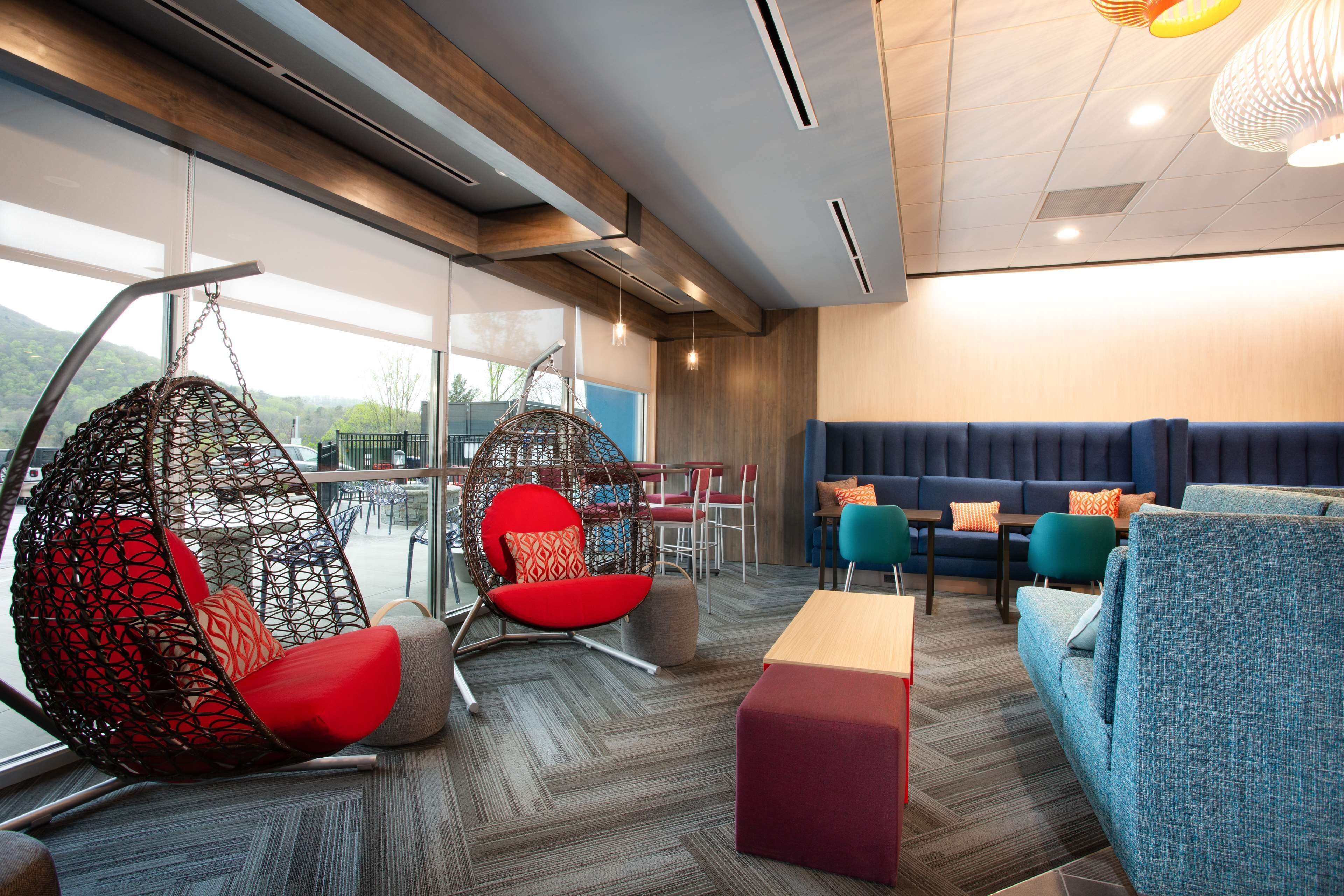 A modern lounge area with hanging chairs, sofas, and a bar area.