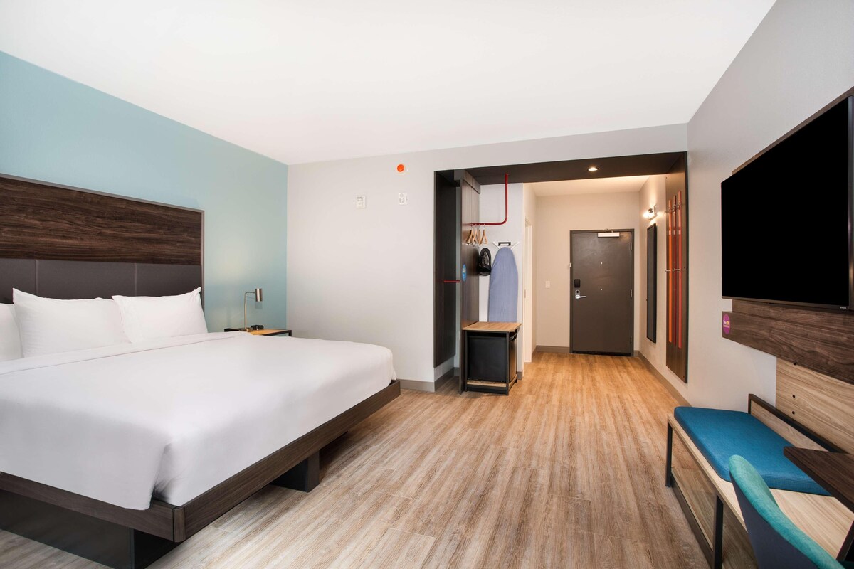Une chambre d’hôtel moderne dotée d’un grand lit, d’un coin salon, d’une télévision et d’une armoire.