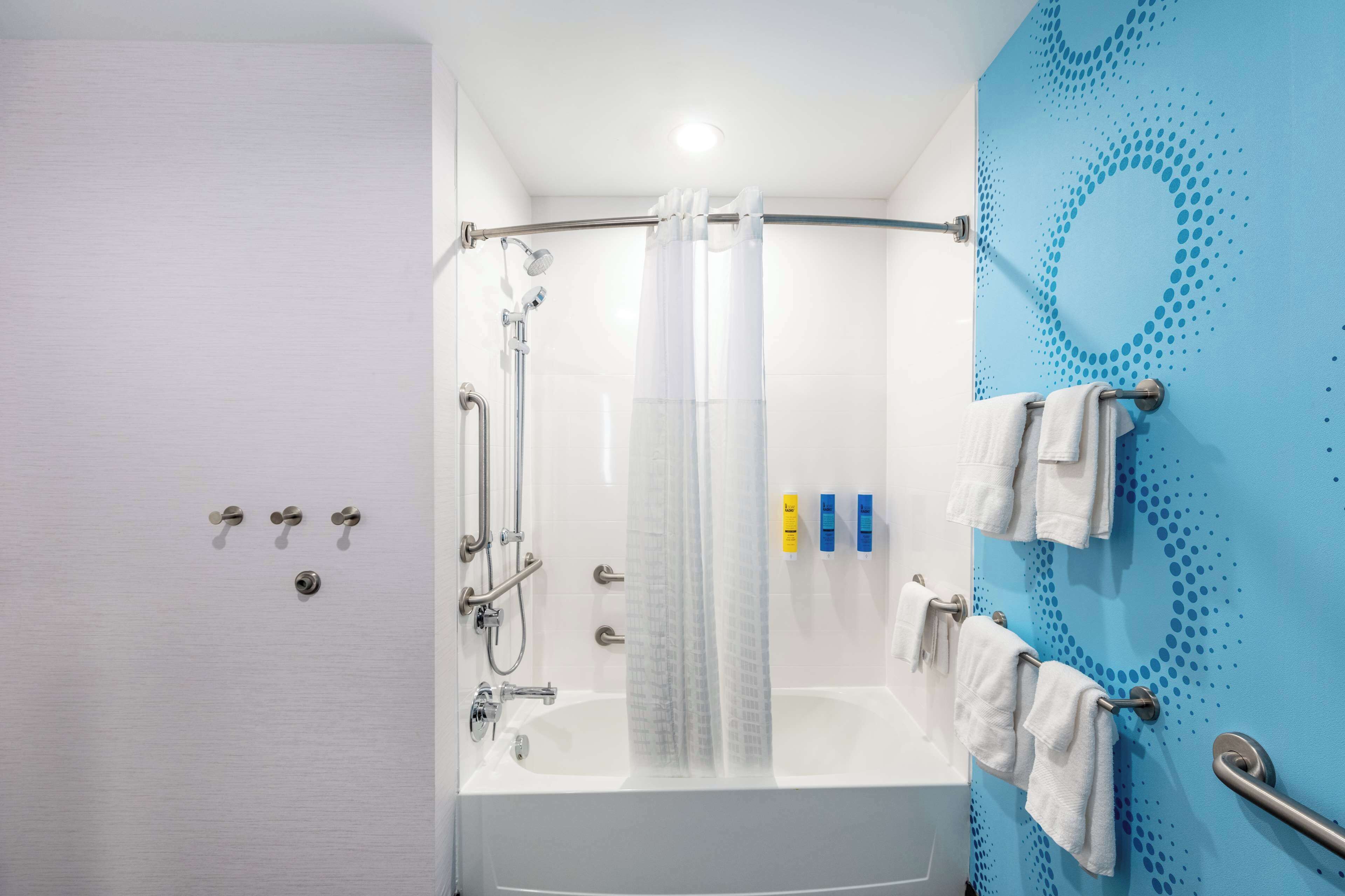 Une salle de bain moderne équipée d’une douche, d’une baignoire et d’un porte-serviettes.