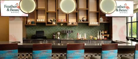 Zona de bar con un letrero que dice "Feather & Bean Bistro", taburetes con asientos azules y un salpicadero con diseño.