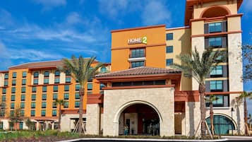 A hotel with a prominent "HOME 2" sign, multiple floors, and a central entrance with an archway.