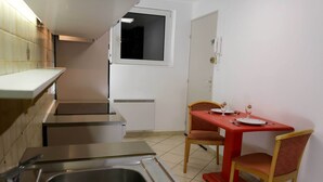 A compact kitchen with a sink, a small countertop, and a window above the door. - Maison Rurale En Bordure De Forêt (Schirmeck)