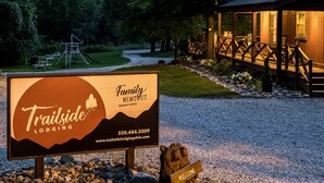 Señal de Trailside Lodging con un número de contacto y sitio web.