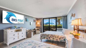 Ein Hotelzimmer mit Bett, Schreibtisch, Stuhl, Kommode und einem großen Fenster mit Blick.