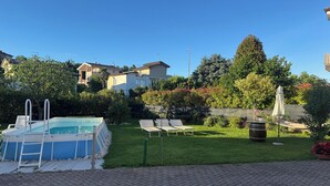A backyard with a swimming pool, lounge chairs, and a hammock. - House with private pool x families and companies (Caprino veronese)