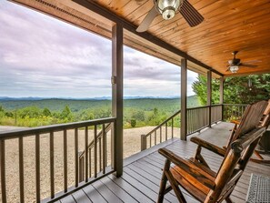 Une terrasse en bois offrant une vue sur un paysage montagneux.