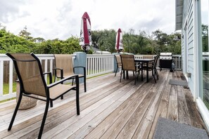 A wooden deck with outdoor furniture and a grill. - Beach Haven (saint augustine)