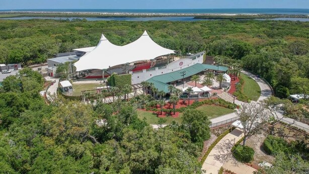 A large, white, tent-like structure surrounded by lush greenery and a clear blue sky. - Beach Haven (saint augustine)