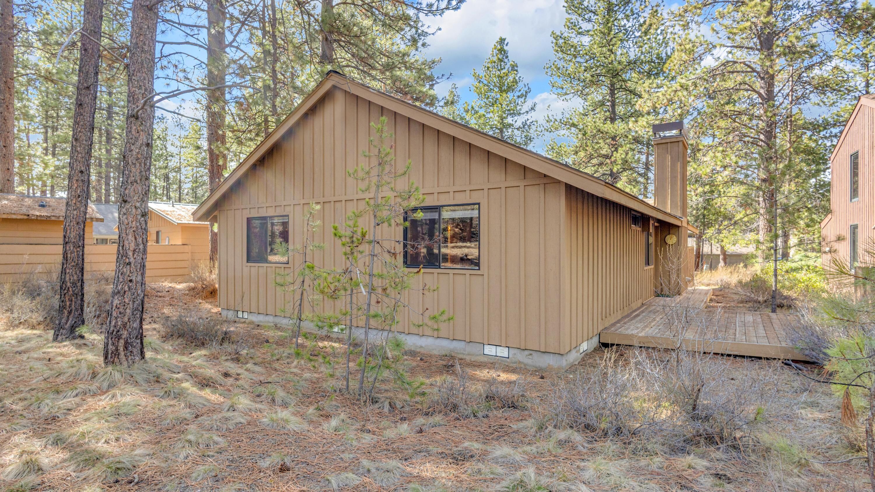 A cabin with a sloped roof, two windows, and a small porch.