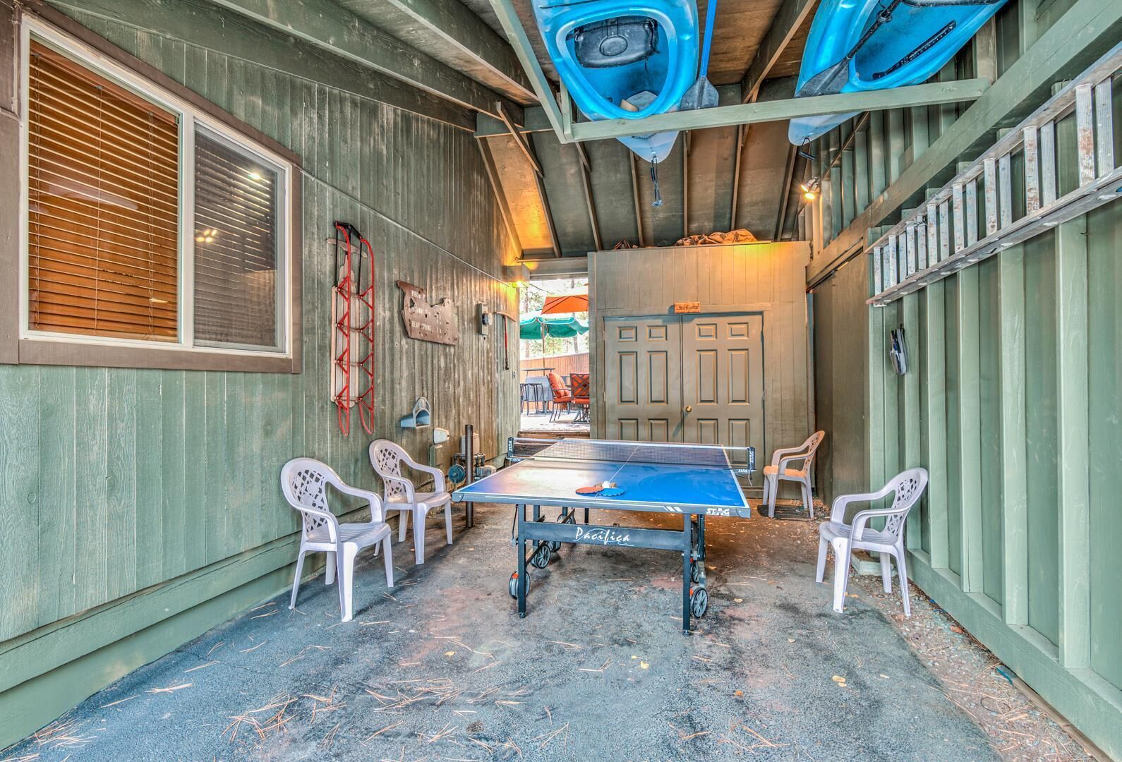 A ping pong table in a rustic indoor setting with wooden walls and metal beams.