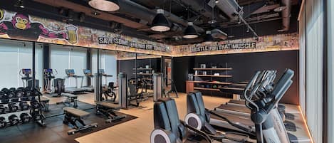 A modern gym with treadmills, weight machines, and free weights.