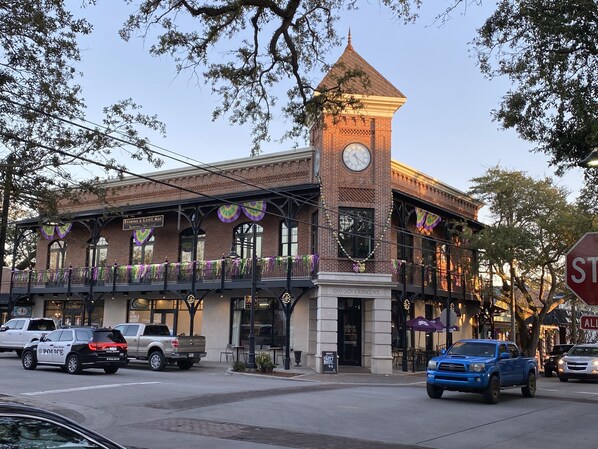 A historic building with a clock tower, a covered walkway, and a sign for 'Rushing & Gues LLC'.