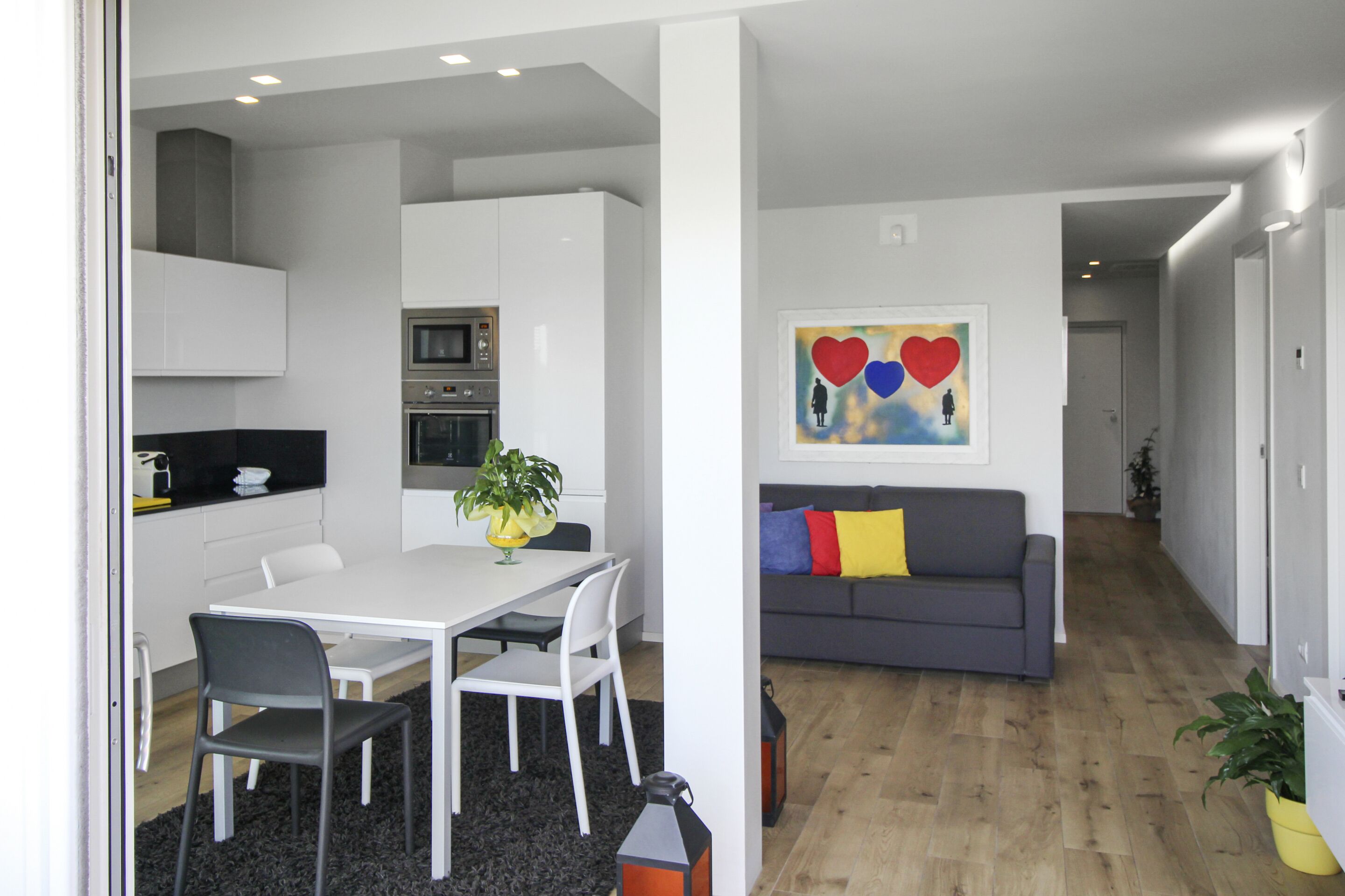A modern kitchen with white cabinets and a dining area with a white table and chairs.