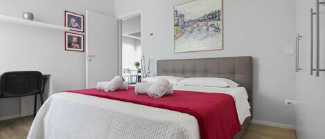 A hotel room with a bed, a desk, and a chair.