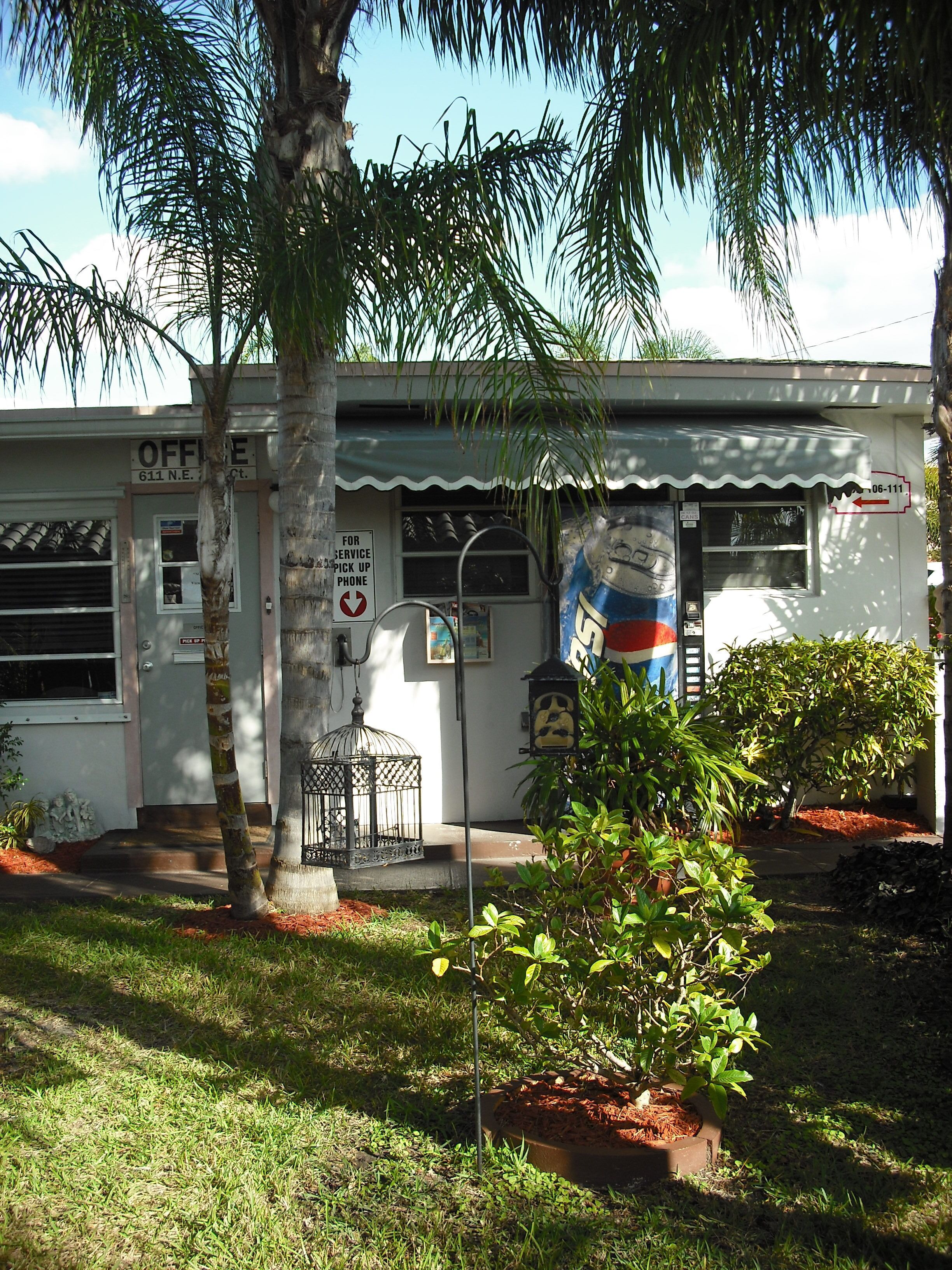 A small building with a sign reading "OFFICE 611 N.E. Ct." and a phone service sign.