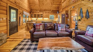 A cozy cabin interior with a leather sofa, a wooden coffee table, and a checkered rug. - Blue Ridge - Creek Front Paradise w/great outdoors (Blue Ridge)