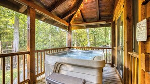 A wooden cabin with a hot tub on a porch, surrounded by trees. - Blue Ridge - Creek Front Paradise w/great outdoors (Blue Ridge)