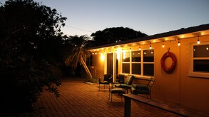 Zona patio con posti a sedere all'aperto e luci decorative.