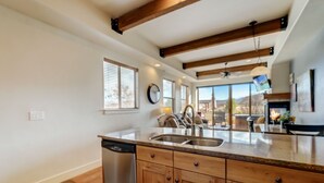 Una cocina moderna con armarios de madera, lavavajillas y una isla grande con pileta.