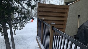 A wooden staircase with metal railings leading to a covered area. - Fernie Alpine Resort accommodation Thunder Ridge Chalet Truely Ski in/Ski out  (Fernie)