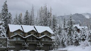 A lodge with a symmetrical facade, multiple balconies, and a snow-covered landscape. - Fernie Alpine Resort accommodation Thunder Ridge Chalet Truely Ski in/Ski out  (Fernie)