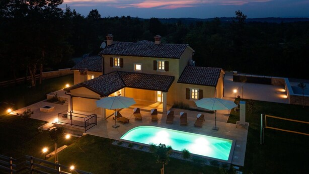 A two-story house with a swimming pool, outdoor seating, and a well-lit patio area. - Beautiful private villa for 6 people with WIFI, private pool, A/C, TV, terrace and pets allowed (Pazin)