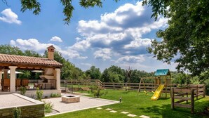 A patio area with a pergola, outdoor seating, a fire pit, and a play structure with a slide. - Beautiful private villa for 6 people with WIFI, private pool, A/C, TV, terrace and pets allowed (Pazin)
