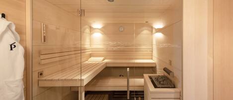 Eine Sauna mit Holzbänken, einem Handtuchhalter und einem Holzschrank.
