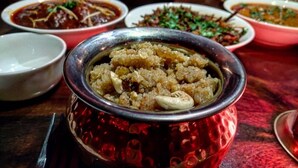 Una mesa con varios platos, incluyendo un plato principal en un bol de metal.