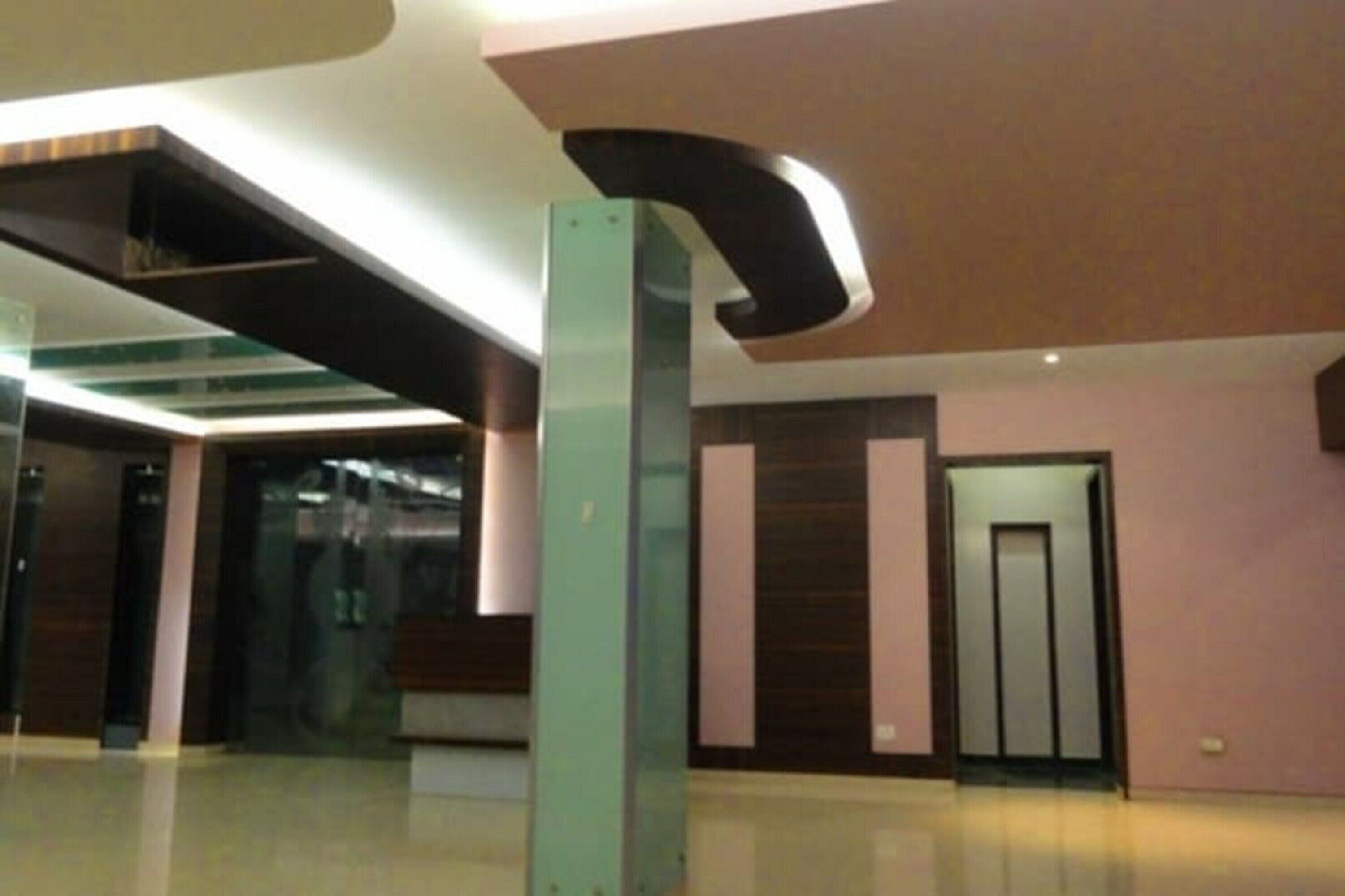 Un intérieur moderne avec un plafond incurvé, un ascenseur en verre et un mur revêtu de panneaux en bois.