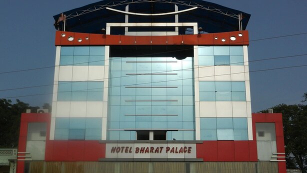 A hotel named "Hotel Bharat Palace" with a modern facade, large glass windows, and a prominent red and white color scheme.