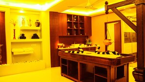 Une pièce avec une table de billard, des étagères ornées d’objets décoratifs et un ventilateur de plafond.