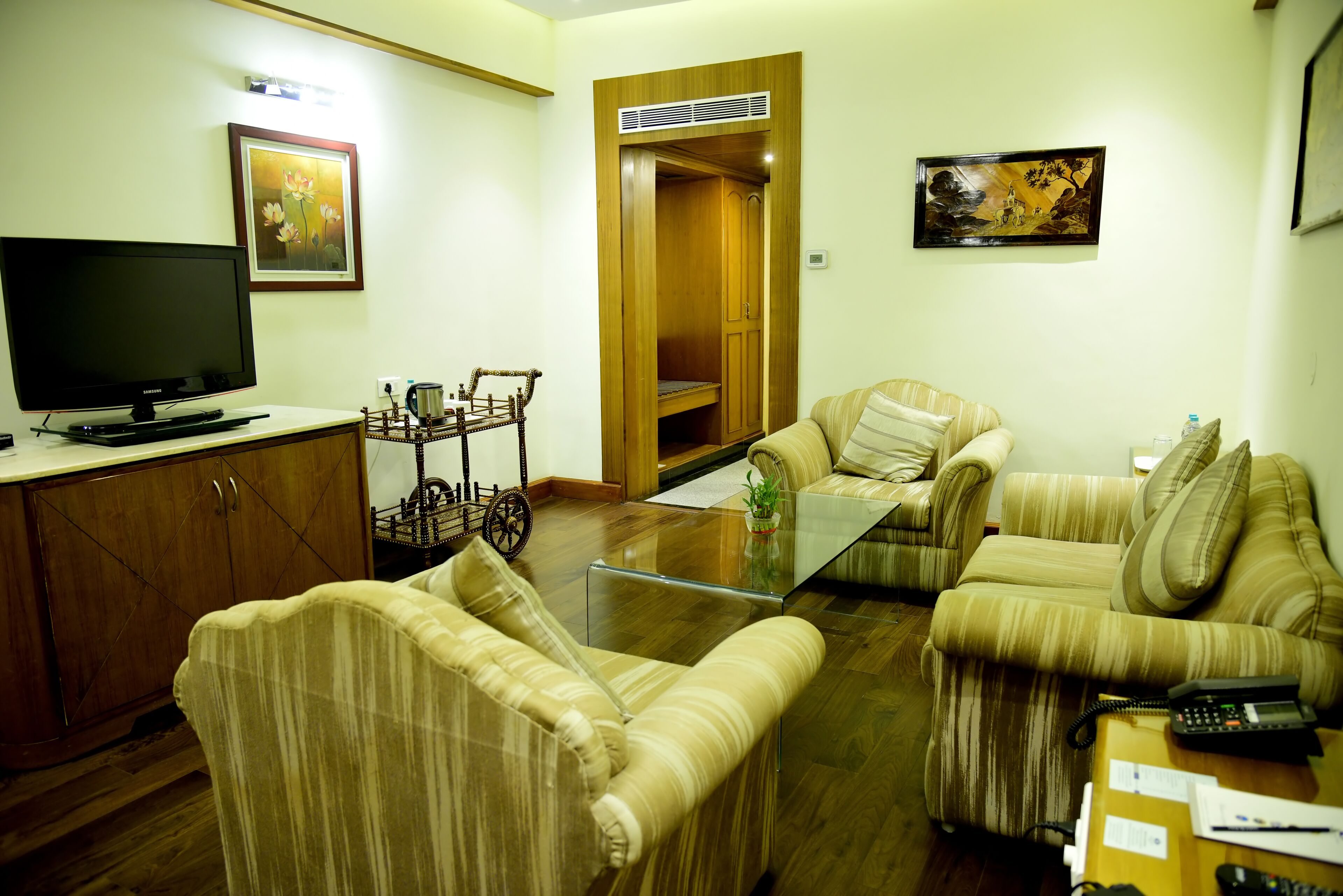 A living room with a sofa set, a television, and a wooden cabinet.