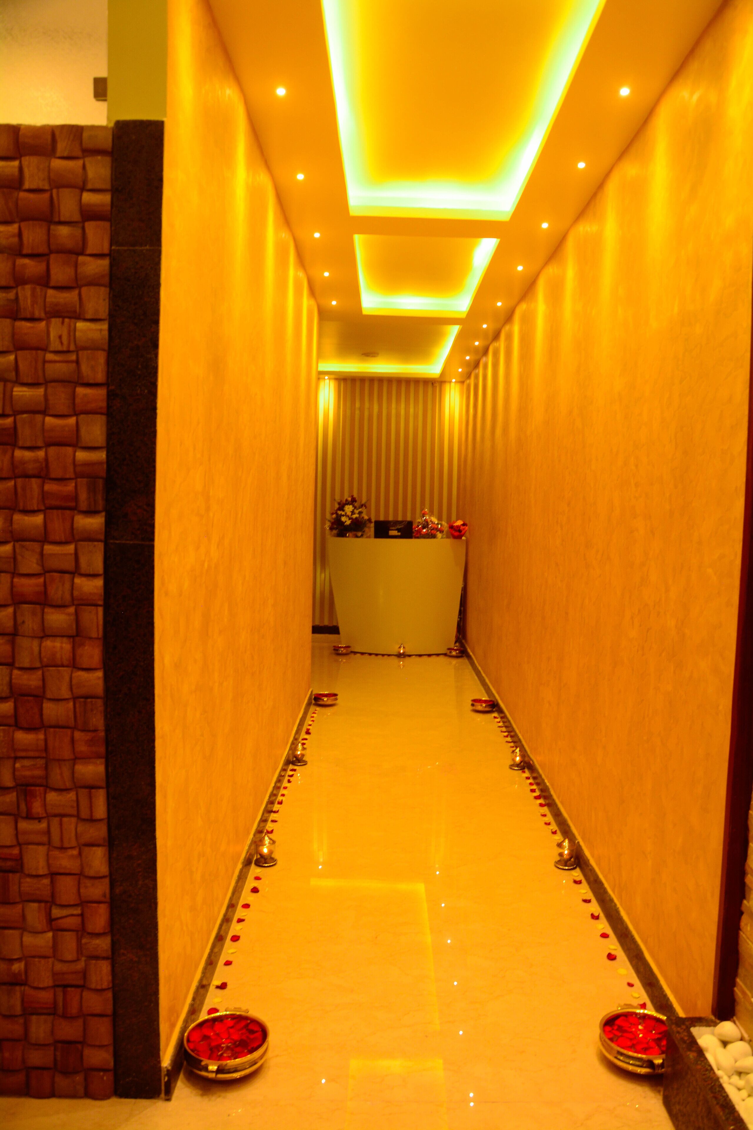 A corridor with a polished floor, a reception desk, and a decorative wall.