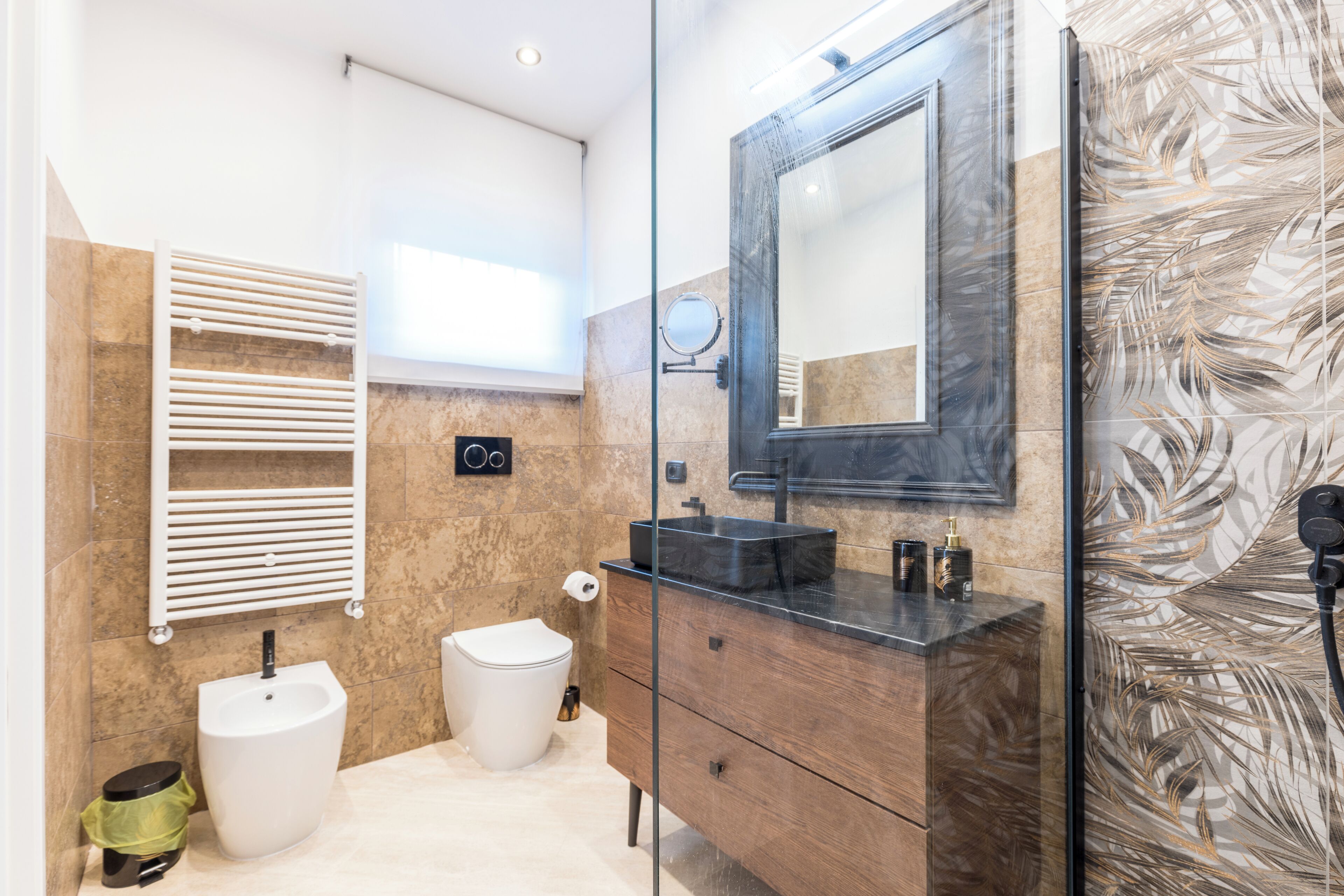 A modern bathroom with a glass shower enclosure, a vanity with a mirror, a sink, and a toilet.