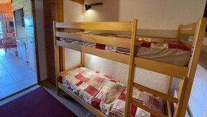 A bunk bed with three levels, a wooden headboard, and a wall-mounted light fixture. - Studio cabin 5 pers. with south balcony and GARAGE, Les Saisies (Les Saisies)