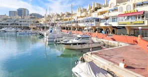 Stroll along the waterfront marina, surrounded by a variety of boats and commercial establishments.