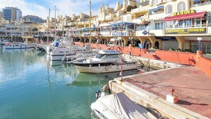 A marina with boats docked, a waterfront restaurant, and buildings with balconies. - Stella Maris - Paseo Maritimo, Fuengirola, Andalucía (Fuengirola)