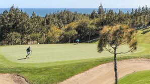 Un campo de golf con vistas despejadas al océano y un búnker arenoso.