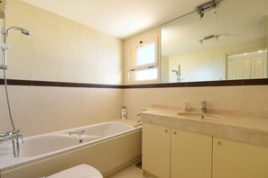 Ein Badezimmer mit Badewanne, Waschbecken und Spiegel.