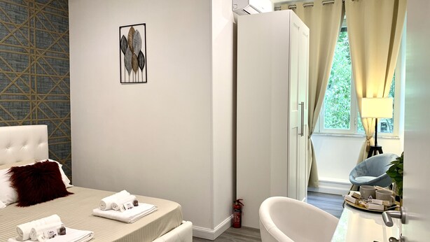 A modern hotel room with a bed, a bathroom, and a view of the outdoors. - 4VaticanRooms (Rome)