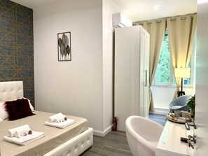 Una habitación de hotel moderna con cama, baño y vistas al exterior.