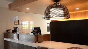 A reception desk with a modern design, a large pendant light, and a view of the reception area. - Staybridge Suites Nashville SE - Murfreesboro by IHG (Murfreesboro)