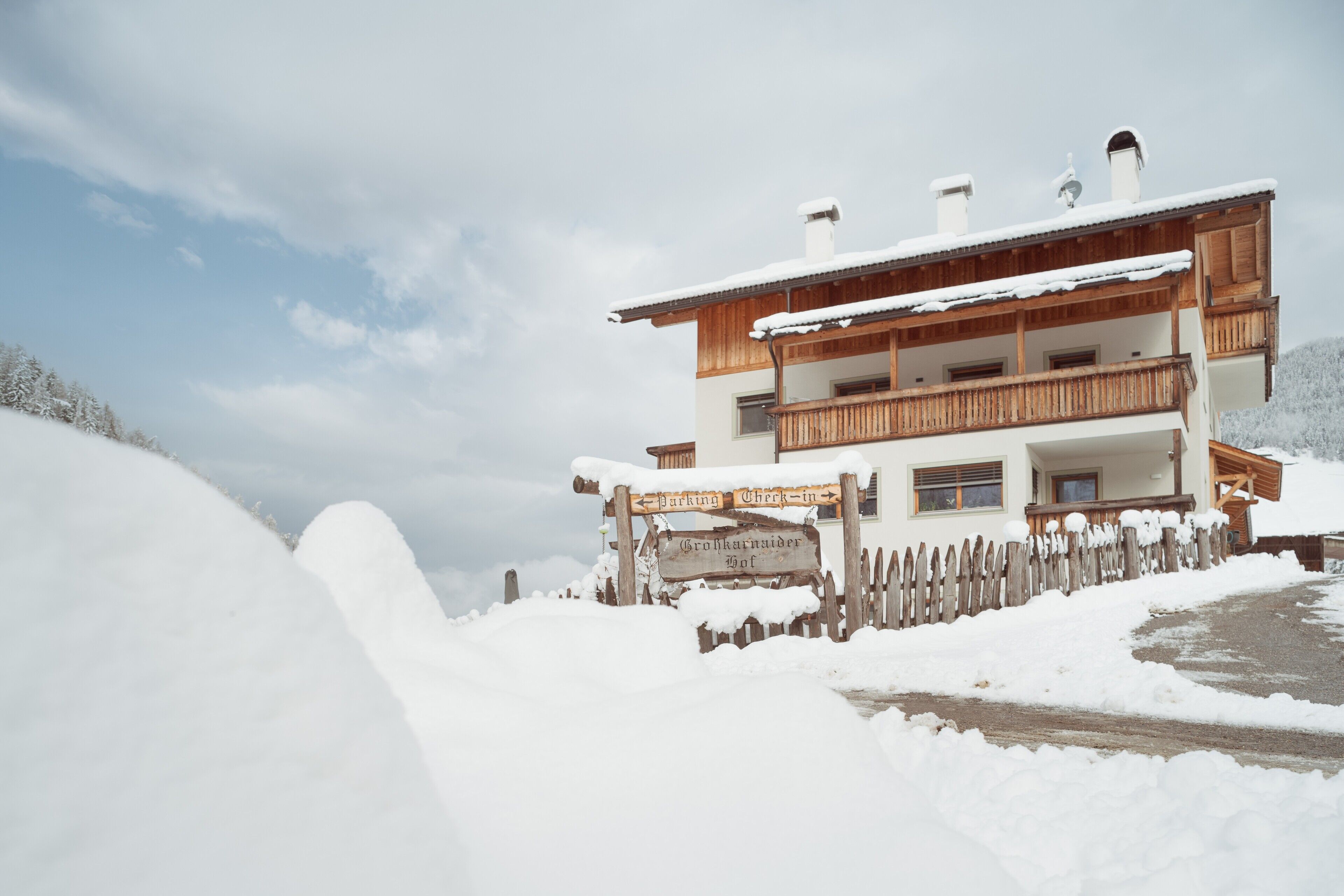 Un bâtiment en bois à deux étages, sur lequel est apposée une enseigne indiquant un espace de stationnement.