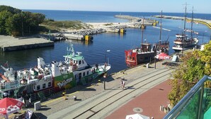 A harbor with boats docked, a pedestrian walkway, and a clear view of the sea. - Hotel Hanseatic  - adults only (Kolobrzeg)