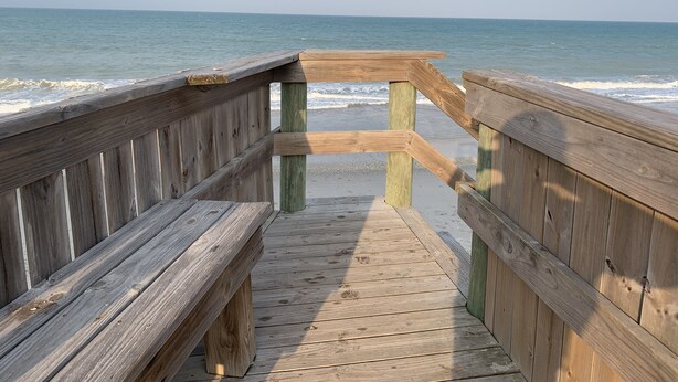 A wooden boardwalk leading to a beach with waves in the background. - Enjoy our Private Beach Access! (Vero Beach)
