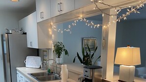 A modern kitchen with a built-in dishwasher, a coffee maker, and a sink. - Enjoy our Private Beach Access! (Vero Beach)