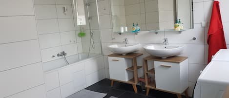 Bañera, secador de pelo, pantuflas, toallas