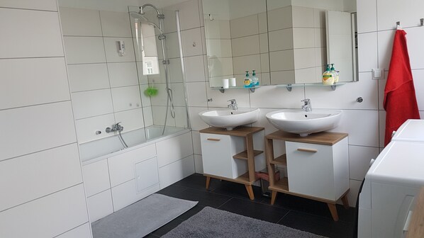 Bathtub, hair dryer, slippers, towels