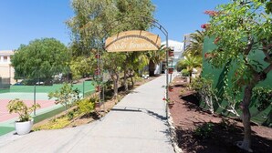 A pathway leading to a building with a sign that reads "Bienvenidos a Vista Hermosa."